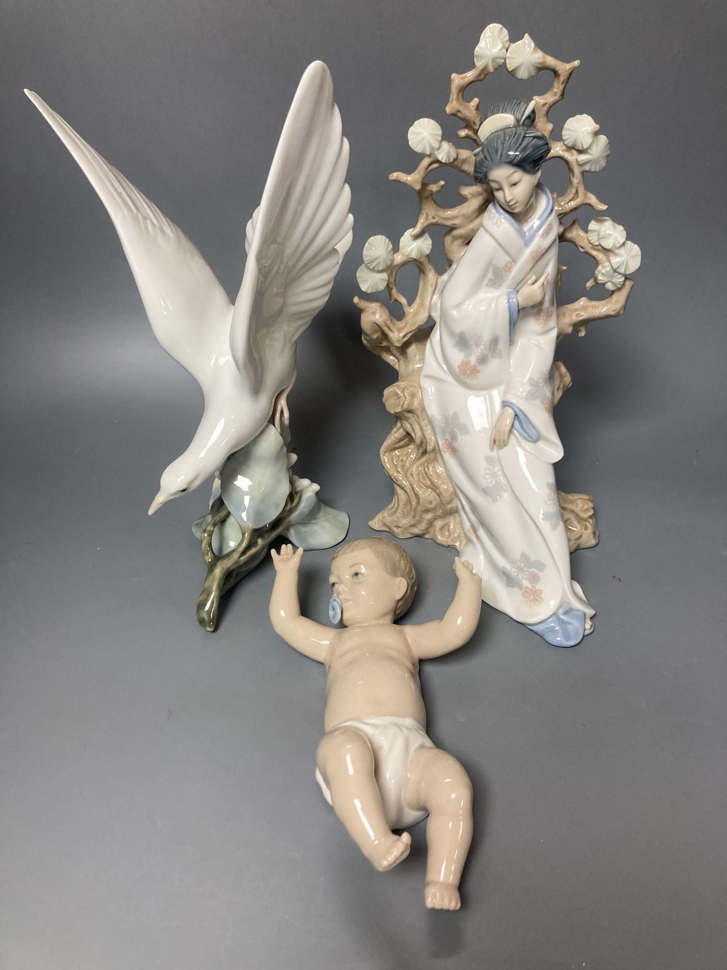A Lladro figure of a geisha, 30cm high and another of a seagull, 29cm high and a Nao figure of a baby, length 21cm